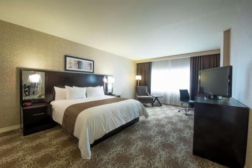 a hotel room with a bed and a flat screen tv at DoubleTree by Hilton Binghamton in Binghamton