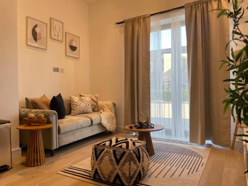 a living room with a couch and a large window at Luxury 2 bedroom Flat Sutton in Sutton