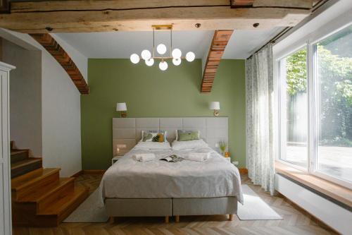 een slaapkamer met een groot bed en een groene muur bij Dom w Starym Parku in Biskupice