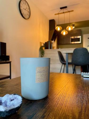 a cup sitting on top of a wooden table at L'Ovalie Appartement T2 CLIMATISÉ et JARDIN in Toulouse
