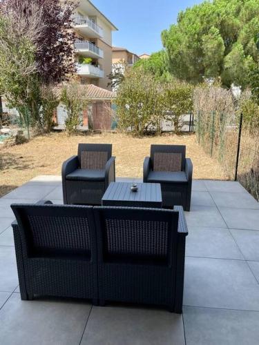 three chairs and a table and a table and chairs at L'Ovalie Appartement T2 CLIMATISÉ et JARDIN in Toulouse