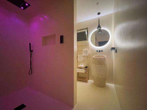 La salle de bains est pourvue d'un éclairage violet et d'un lavabo. dans l'établissement De Sio Village, à Peschici