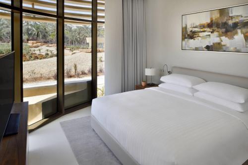 a bedroom with a white bed and a large window at Riyadh Diplomatic Quarter - Marriott Executive Apartments in Riyadh