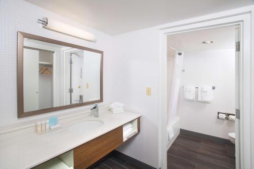 bagno bianco con lavandino e specchio di Hampton Inn & Suites Annapolis ad Annapolis