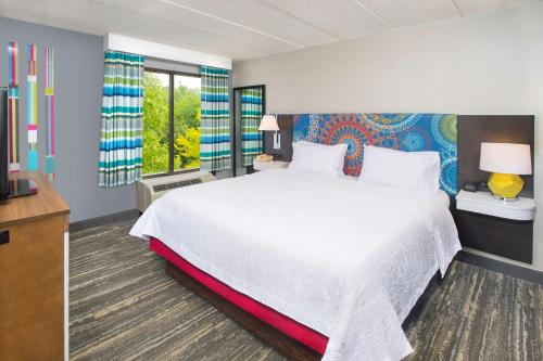 a bedroom with a large white bed and windows at Hampton Inn & Suites Annapolis in Annapolis