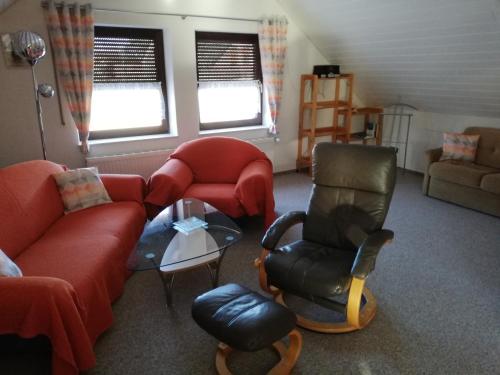 a living room with a couch and a chair at Ferienwohnung „An der olen Au“ in Tönnhausen
