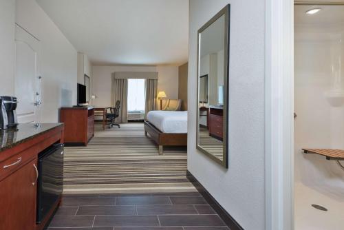 um quarto de hotel com uma cama e um espelho grande em Hilton Garden Inn Philadelphia-Fort Washington em Fort Washington