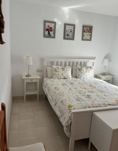 um quarto com uma cama com duas mesas e dois candeeiros em VILLA CORVINA em Chiclana de la Frontera