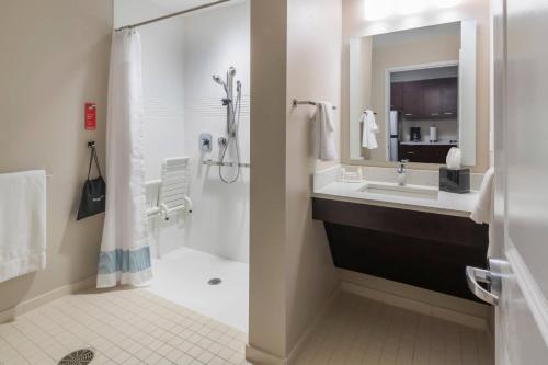 y baño con lavabo y ducha. en Towneplace Suites By Marriott Hays en Hays