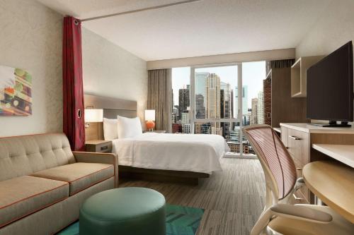 a hotel room with a bed and a large window at Home2 Suites By Hilton Chicago River North in Chicago