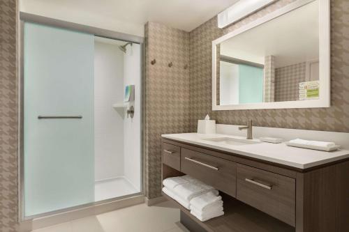 a bathroom with a sink and a shower and a mirror at Home2 Suites By Hilton Chicago River North in Chicago