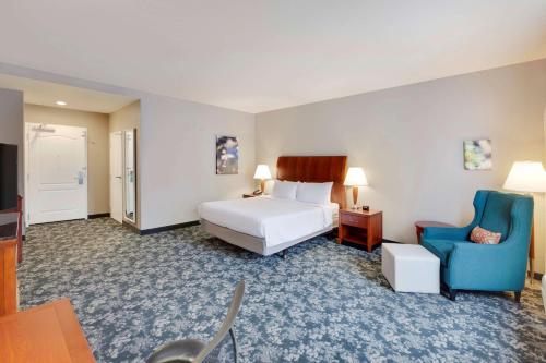 Habitación de hotel con cama y silla azul en Hilton Garden Inn Austin North, en Austin
