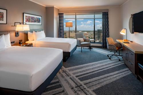 a hotel room with two beds and a desk at Hilton Garden Inn Austin University Capitol District in Austin