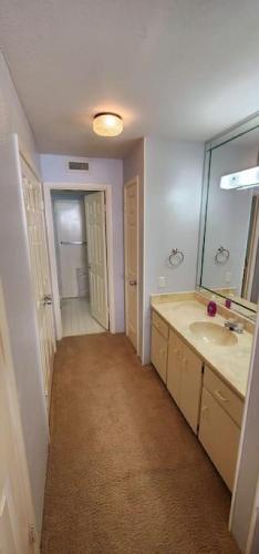 a bathroom with a sink and a mirror at Aliki Atrium Beachfront Condo in Ormond Beach