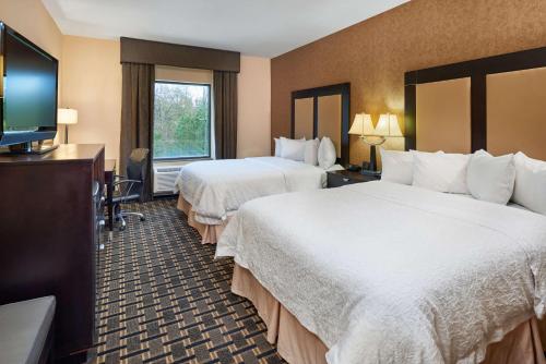 a hotel room with two beds and a television at Hampton Inn & Suites Longview North in Longview