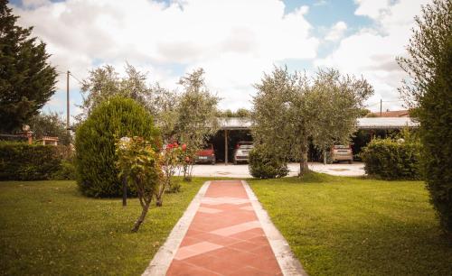 a brick walkway in a yard with trees at Agriturismo Poggio alle Calle in Saturnia
