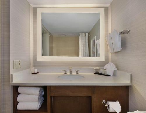 uma casa de banho com lavatório, espelho e toalhas em Embassy Suites by Hilton Anaheim North em Anaheim