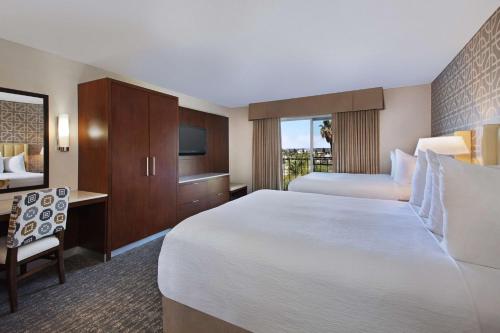 a hotel room with a large bed and a desk at Embassy Suites by Hilton Anaheim North in Anaheim