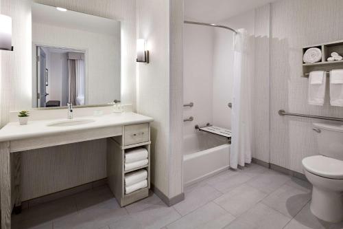 a white bathroom with a sink and a toilet at Homewood Suites By Hilton Long Beach Airport in Long Beach