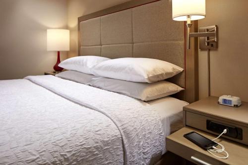 a hotel room with a large bed with white pillows at Hampton Inn Long Beach Airport, Ca in Long Beach