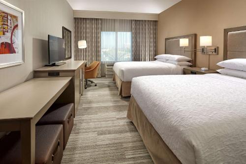 a hotel room with two beds and a television at Hampton Inn Long Beach Airport, Ca in Long Beach