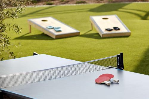 a ping pong table with a tennis racket on it at Hampton Inn Long Beach Airport, Ca in Long Beach