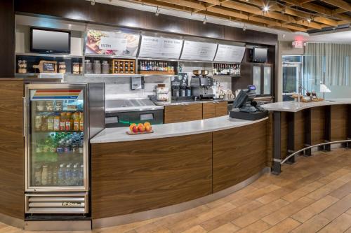 a restaurant with a counter with a drink refrigerator at Courtyard by Marriott Austin Parmer Tech Ridge in Austin