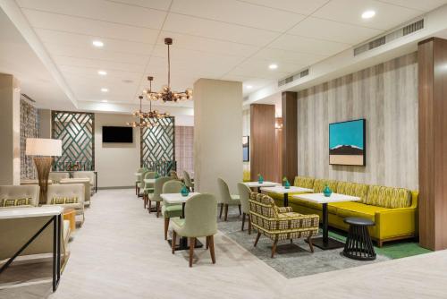 a lobby with tables and chairs and a waiting room at Hampton Inn & Suites Miami Wynwood Design District, FL in Miami