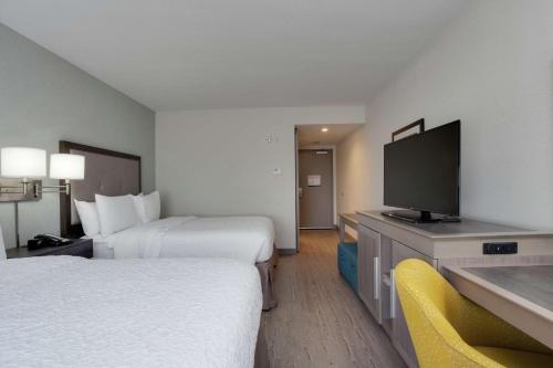a hotel room with two beds and a flat screen tv at Hampton Inn & Suites Miami Wynwood Design District, FL in Miami