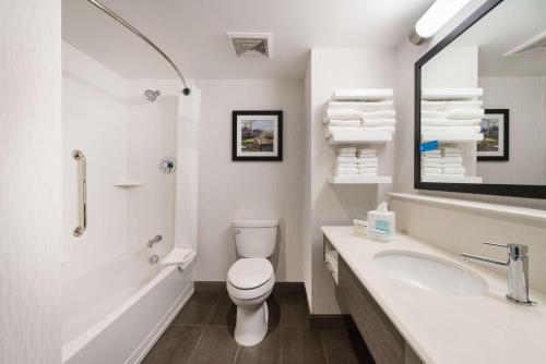 a white bathroom with a toilet and a sink at Hampton Inn & Suites Miami Wynwood Design District, FL in Miami