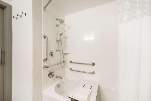 Hampton Inn & Suites Miami Wynwood Design District, FL في ميامي: حمام أبيض مع حوض استحمام ودش