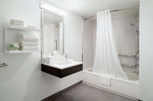 a white bathroom with a sink and a shower at Hampton Inn Manhattan Chelsea in New York