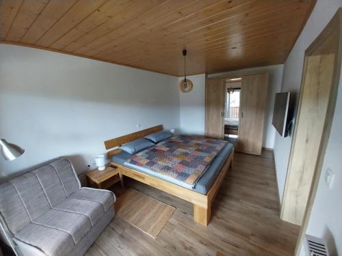 niewielka sypialnia z łóżkiem i kanapą w obiekcie Apartments at Klemen w mieście Zgornje Gorje