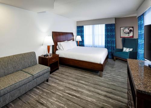 a hotel room with a bed and a couch at Hilton Garden Inn Omaha Downtown-Old Market Area in Omaha