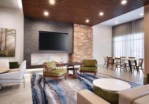 a lobby with a waiting room with tables and chairs at Fairfield Inn & Suites by Marriott Houston League City in League City