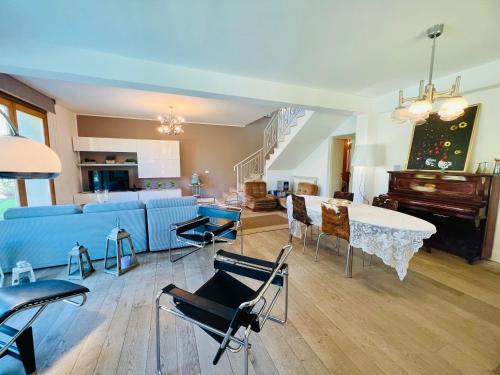 - un salon avec un canapé bleu, une table et un piano dans l'établissement Villa Donna Vicenza, à Cinisi