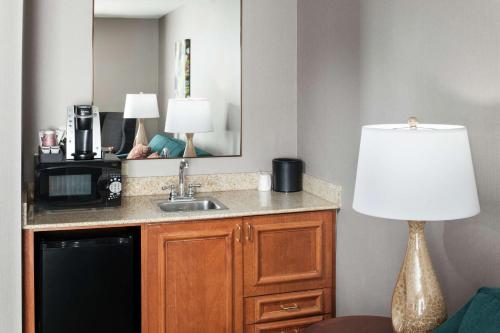 a hotel room with a sink and a lamp at Hilton Garden Inn Naperville/Warrenville in Warrenville