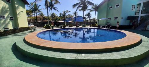 una gran piscina con un círculo de madera alrededor en Condomínio Golden Dolphin Village, en Porto Seguro