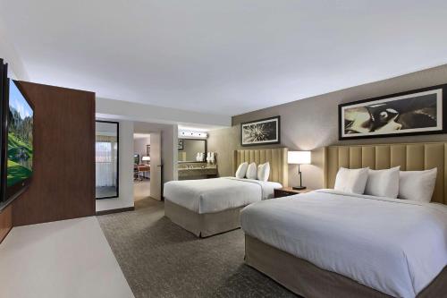 una camera d'albergo con due letti e una televisione di Embassy Suites by Hilton Palm Desert a Palm Desert