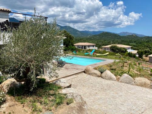 une villa avec une piscine et des montagnes en arrière-plan dans l'établissement Villa en résidence à Sotta vue panoramique sur Porto-Vecchio !, à Sotta
