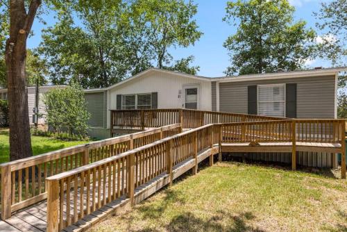 a home with a deck and a house at Accessible 3BR Sleeps 12 Pet-Friendly Conroe Stay in Conroe