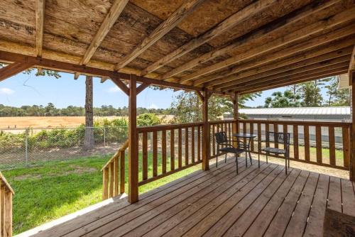 a wooden deck with a table and chairs on it at Accessible 3BR Sleeps 12 Pet-Friendly Conroe Stay in Conroe