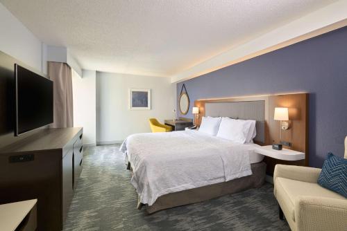 a hotel room with a bed and a flat screen tv at Hampton Inn Washington DC - Convention Center in Washington