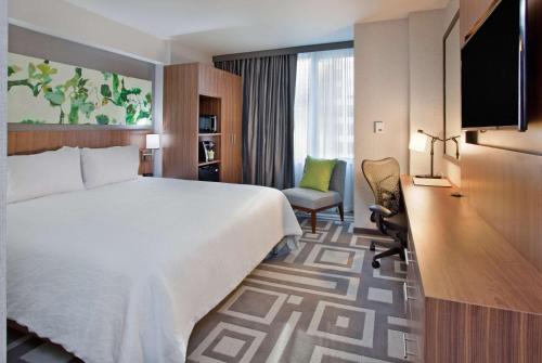 um quarto de hotel com uma cama grande e uma secretária em Hilton Garden Inn New York Central Park South-Midtown West em Nova York