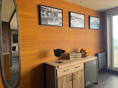 een kleedkamer met een spiegel en een houten muur bij This one in Concarneau