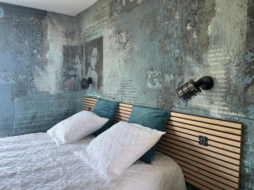 een bed met 2 kussens in een slaapkamer bij This one in Concarneau