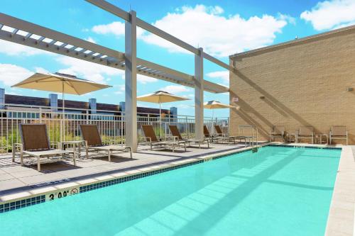 a swimming pool with lounge chairs and umbrellas at Hilton Garden Inn Washington DC/Georgetown Area in Washington
