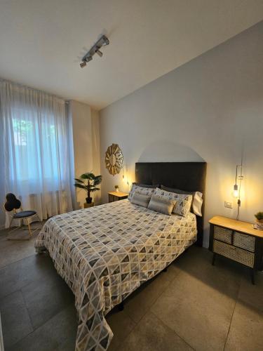 een slaapkamer met een bed, 2 tafels en een raam bij Loft17 in Burgos