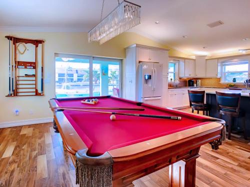 a red pool table in a room with a kitchen at 20 Disc-2 Kg Mstrs, Golf, Fishing, BBQ, Pool, Spa in Cape Coral