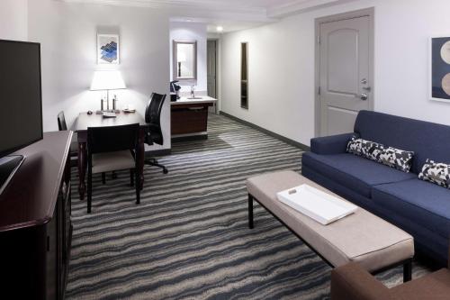 a living room with a couch and a table and a desk at Embassy Suites by Hilton Tampa Brandon in Tampa
